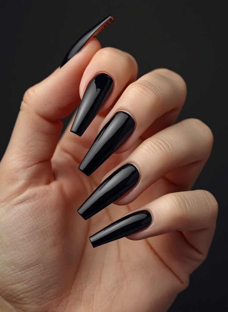 Long glossy black coffin nails with sleek minimalist gothic manicure design
