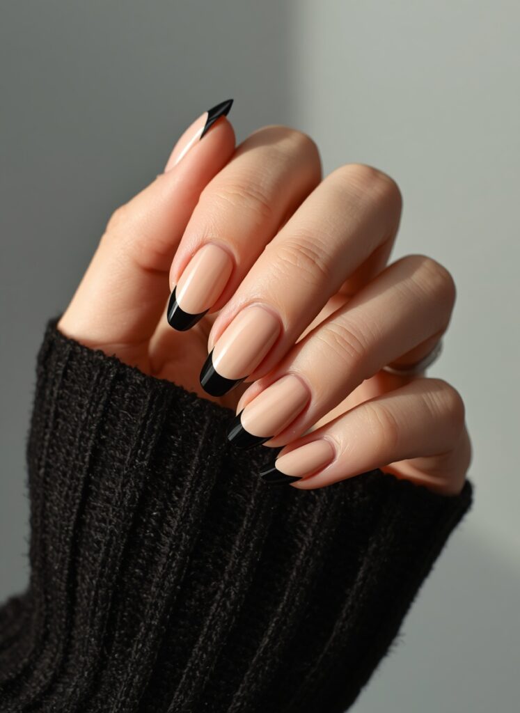 Natural nude and black French tip nails with elegant almond shaped manicure design