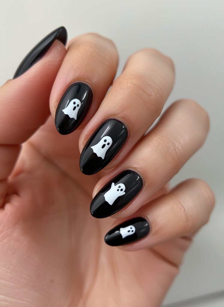 Black Halloween nails with cute white ghost nail art and glossy spooky manicure design