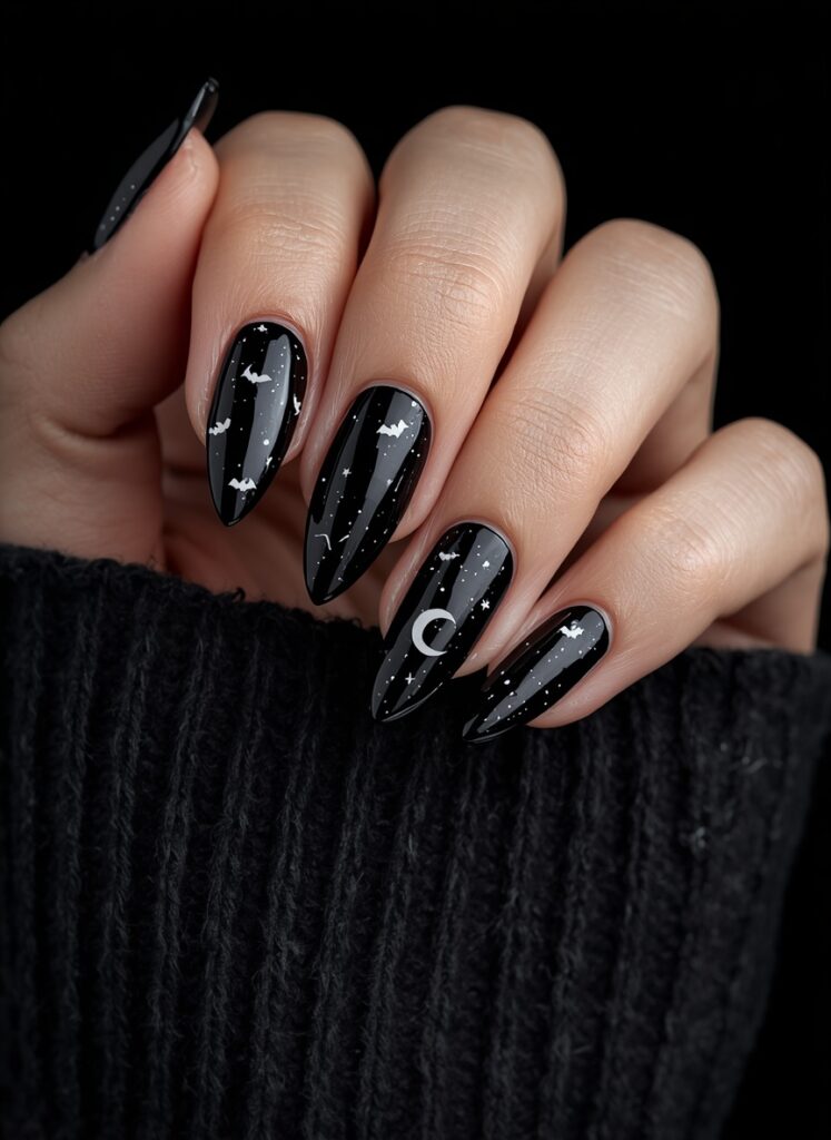Black Halloween nails with moon, stars and bat nail art featuring glossy gothic night sky design
