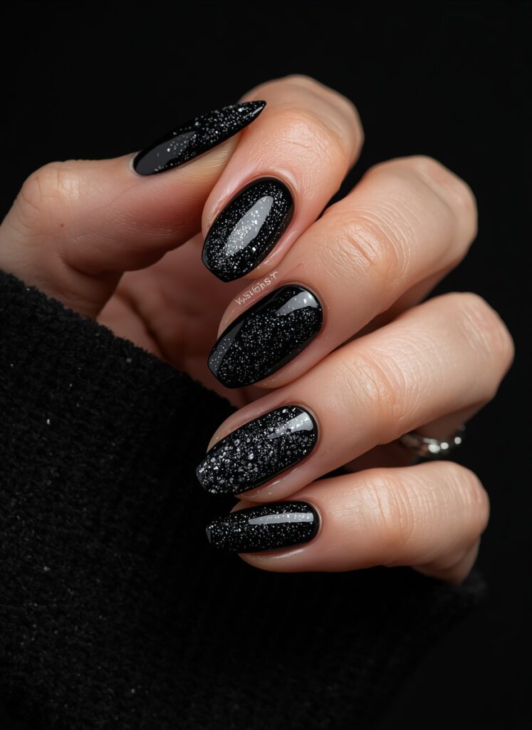 Black glitter nails with glossy finish and sparkling dark manicure design for Halloween and gothic style