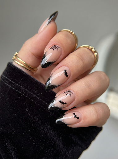 Elegant Halloween French tip nails with black tips, tiny bats, spider webs, and minimalist spooky nail art on almond shaped nails